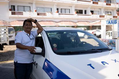 José Pérez (58 years old) next to his taxi, whose windshield broke during the hurricane.