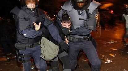 Dos agentes antidisturbios inmovilizan a un joven el 25-S en Madrid.