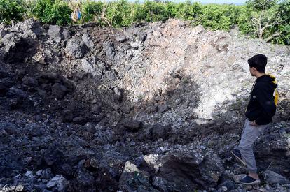 Un niño libanés mira el cráter producido por un bombardeo israelí, en Alqulaylah, en el sur de Líbano, este viernes.