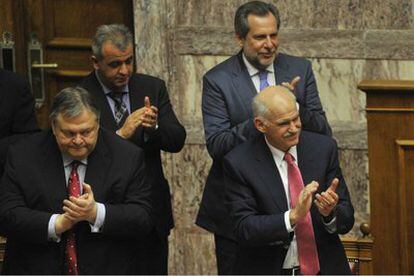 El primer ministro Yorgos Papandreu y su equipo de Gobierno aplauden la aprobación en el Parlamento.
