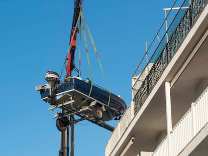 Una grúa retiraba el martes la lancha que un vecino de Es Castell, en Menorca, guardó en la terraza de su piso.