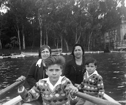 Un niño, acompañado de su familia, rema en una barca del lago del Retiro en 1930.
