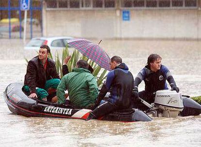Varios vecinos de Getxo son evacuados por la Ertzaintza en una lancha neumática, cerca del polideportivo de Fadura.