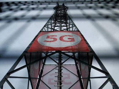 Un cartel con el logotipo de 5G sobre una torre de telefonía móvil de Vodafone en Alemania.  