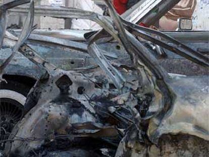 Unos iraquíes miran el coche destrozado de un suicida ayer en Bagdad.