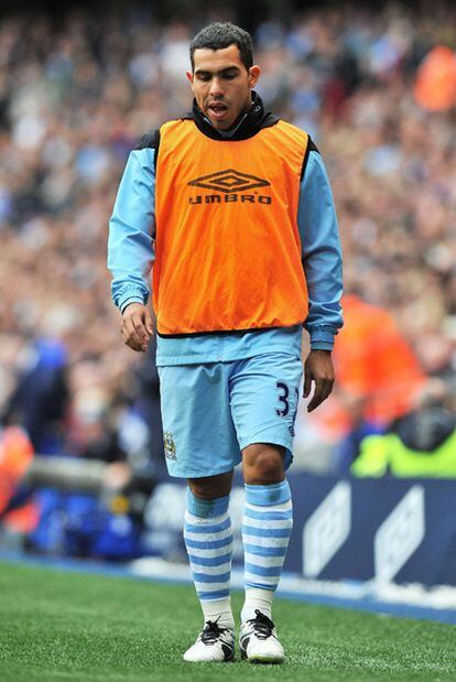 Carlos Tévez calienta durante un partido del Manchester City en la Premier League.
