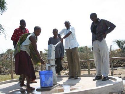 Miembros de una comunidad local latinoamericana sacando agua de un pozo, en un proyecto liderado por Ferrovial.