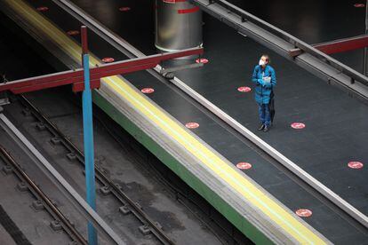 Una mujer con mascarilla espera el metro en Madrid, el viernes.