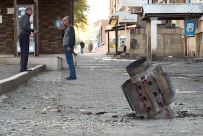 Dos hombres conversan este lunes en una calle de Stepanakert alcanzada por la artillería.