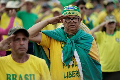 Manifestantes bolsonaristas hacen un saludo militar, este jueves en una protesta golpista ante el cuartel general del Ejército en Brasilia, este jueves.