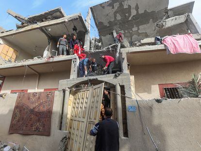Un grupo de palestinos rescata varios cuerpos de fallecidos en un ataque israelí sobre una casa en Rafah, en Gaza.