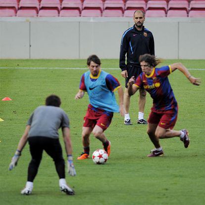 Guardiola observa a Messi y Puyol en el último entrenamiento en Barcelona.