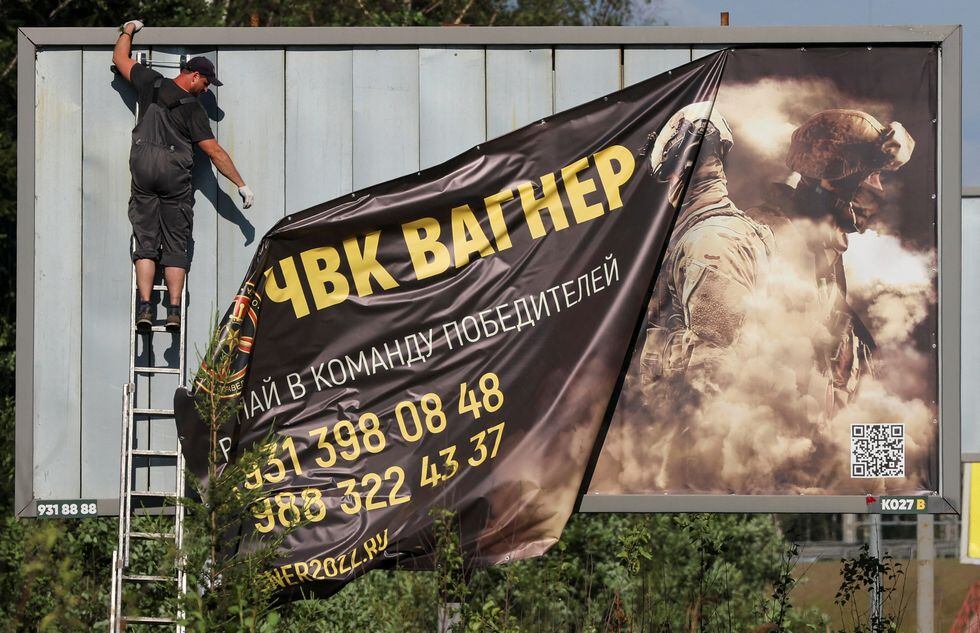 A worker removes an advertising banner promoting service in Wagner private mercenary group on the outskirts of Saint Petersburg, Russia, June 24, 2023. A slogan on the banner reads: "Accede to the team of victors!" REUTERS/Anton Vaganov