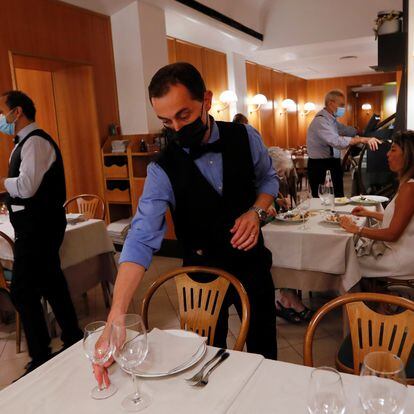 A waiter sets a table at a restaurant as the Italian government is expected to announce limited restrictions for people who have not been vaccinated, including barring them from being served in indoor restaurants or from entering discos, gyms and sports stadiums, in Rome, Italy, July 22, 2021. REUTERS/Remo Casilli