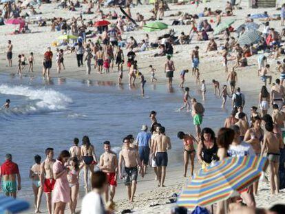 Varias personas disfrutan de las temperaturas veraniegas que han llenado de gente las playas de las R&iacute;as Bajas de Galicia. En la imagen, la playa de Sam&iacute;l en la R&iacute;a de Vigo.
