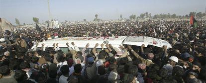 Miles de seguidores rodean el coche con el cadáver de Bhutto en su camino hacia el mausoleo.