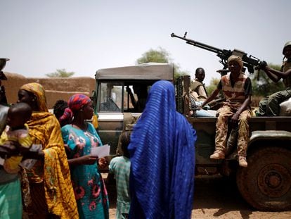 Soldados del ejército de Malí pasan junto a un grupo de mujeres y niños durante una operación en Nadki el 29 de julio de 2019.