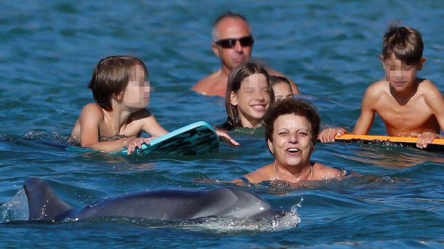 Una familia nada junto al delfín mular, en el verano de 2020. Foto: Lavandeira jr / EFE. En vídeo, imágenes de 'Manoliño' junto a un buzo.