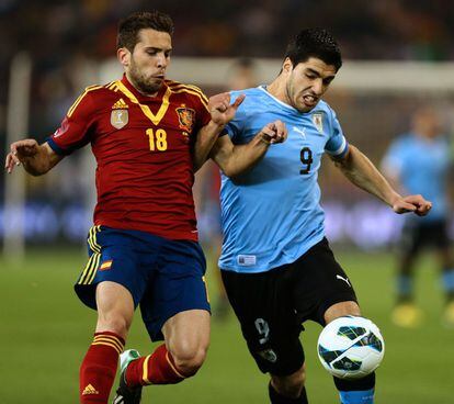 Jordi Alba pelea el balón con Luis Suarez.