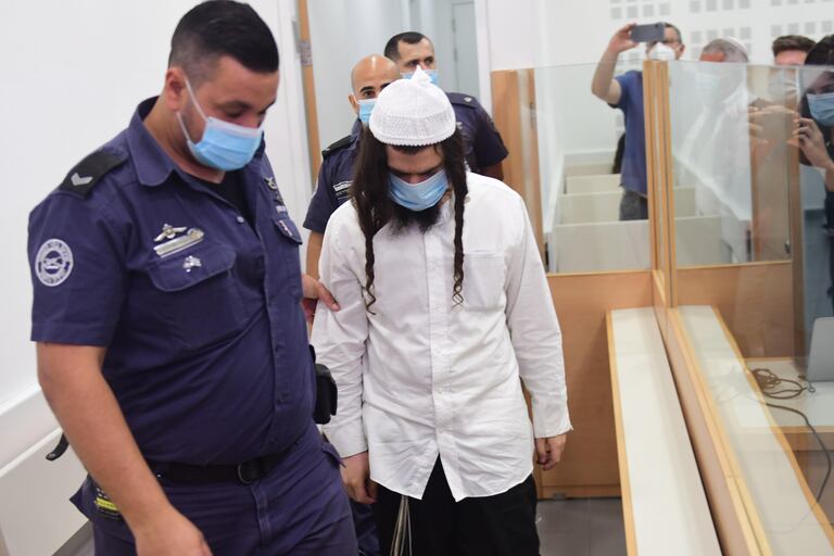 Amiram Ben Uliel es conducido por un agente, este lunes en el tribunal israelí de Lod.