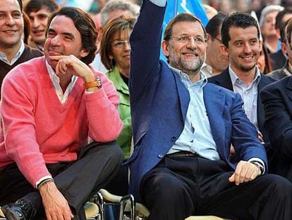 Rajoy saluda con la señal de la victoria junto a Aznar en el mitin de León.