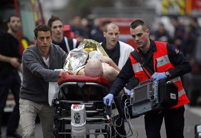 Una persona herida es evacuada fuera de la oficina de la Charlie Hebdo Diario satírico francés, en París. 