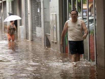 Un hombre camina por una de las calles de Santa Cruz de Tenerife inundadas por el temporal.