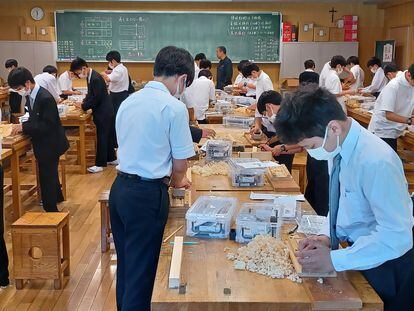 Alumnos del instituto Seiko Gakuin, en Yokohama, durante una clase de manualidades en la que aprenden a fabricar palillos de madera.
