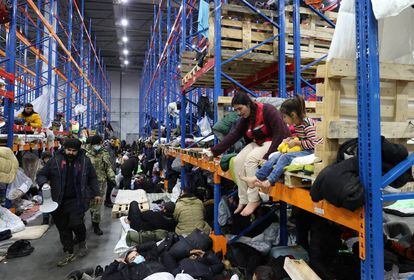 Cientos de refugiados, el jueves en un centro logístico bielorruso cerca de Polonia.