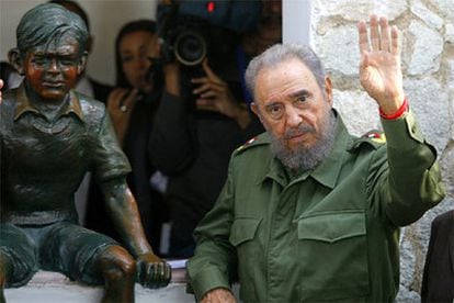 El presidente cubano, Fidel Castro, posa junto a una estatua que recuerda al niño Ernesto Ché-Guevara.