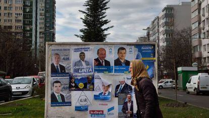 Una mujer pasa delante de varios carteles electorales, el viernes en Bucarest.