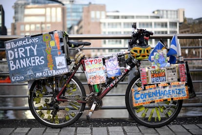 Una bicicleta llena de carteles, durante una protesta del grupo Extinction Rebellion que pide el fin de la financiación de combustibles fósiles por parte de Barclays, frente a las nuevas oficinas del banco en Clyde Place Quay en Glasgow (Escocia), el lunes.