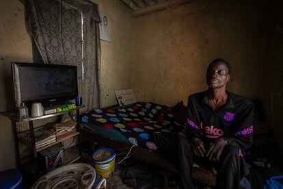 Mohamed Diop, de 40 años, sentado en la cama de su modesta habitación, en el barrio de Yoff Nbenguene. Padece una neuropatía congénita que le dificulta el movimiento.