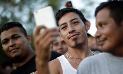 Un migrante de la caravana que viaja desde Centroamérica hacia Estados Unidos usa su teléfono móvil en un campamento improvisado.