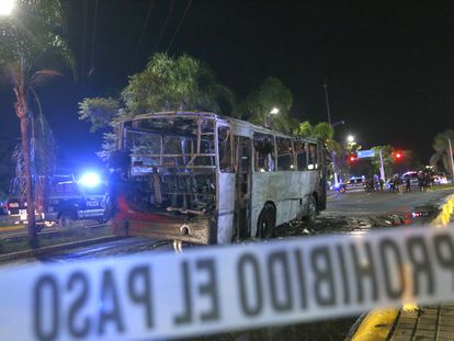 Integrantes de la Policía Municipal resguardan la zona donde fue incendiado un camión de pasajeros en Zapopan, Estado de Jalisco (México), el 9 de agosto.