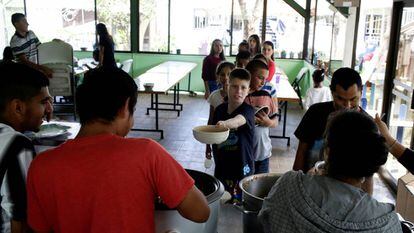 Reparto de comida a un grupo de niños acogidos en una casa de un vecino de San José, en Costa Rica.