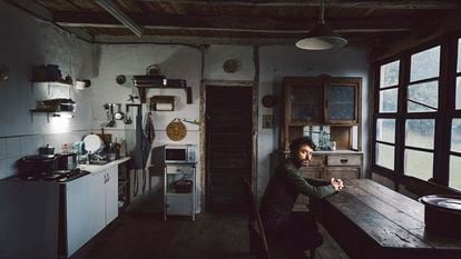 Rodrigo Sorogoyen sentado en la cocina de la casa donde rodó 'As bestas' en Quintela de Barjas, en el Bierzo leonés.