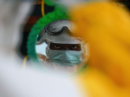 Un trabajador sanitario comprueba su equipo de protección en Kailahun (Sierra Leona) en agosto de 2014 durante el brote de ébola de África occidental.