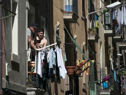Varias personas pasan en confinamiento en los balcones de un bloque de pisos de la Barceloneta.