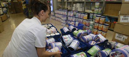 Una mujer retira botes de leche en un establecimiento en Francia.