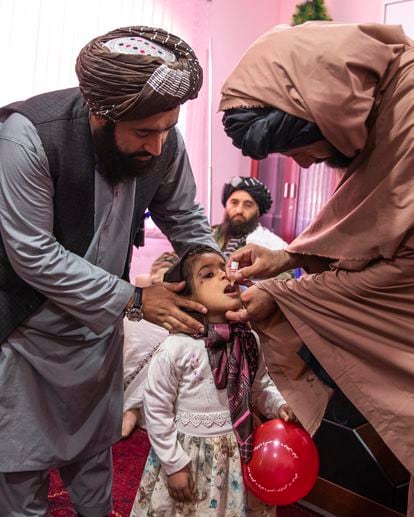 El vicegobernador de Badghis, Mohibullah Asad, ayuda a administrar la vacuna de la polio a una niña. 