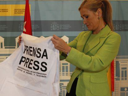 La delegada del Gobierno en Madrid, Cristina Cifuentes, examina el chaleco de identificación para los periodistas.