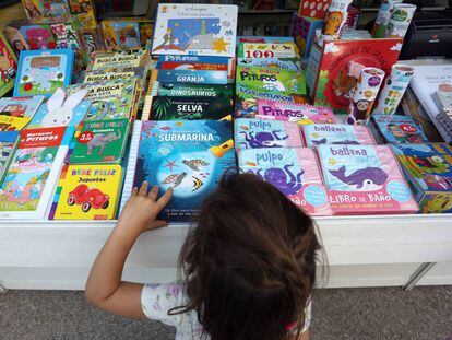 Feria del Libro de Madrid. Una niña mira libros en una caseta.