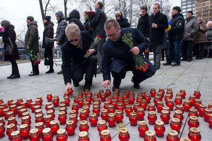 Dos hombres colocan velas a la entrada del Centro Sájarov de Moscú, lugar donde ha transcurrido este martes el velatorio del fallecido líder opositor ruso, Boris Nemtsov.