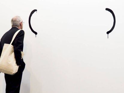 Un hombre observa una obra de la Galeria Luis Adelantado. 