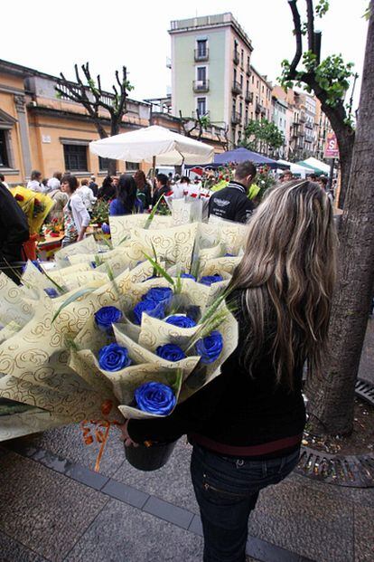 Una mujer vende rosas en una plaza de Girona.