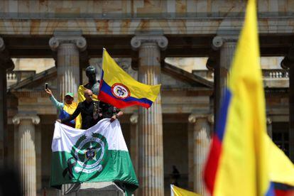 Demonstrators wave the flag of Colombia and the National Police, in Bogotá.