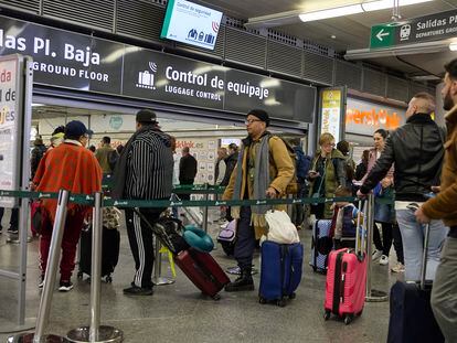 Viajeros con maletas en el control de acceso de la estación Almudena Grandes-Atocha, en Madrid.
