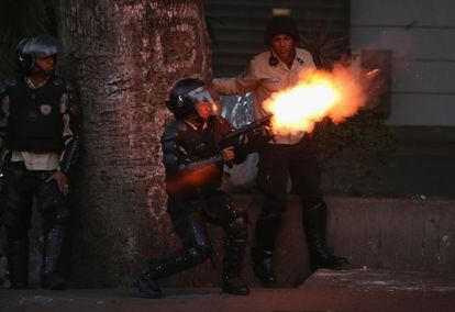 Un policía abre fuego durante las protestas en Venezuela.