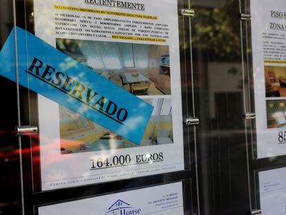 Anuncios de pisos y casas en venta y alquiler en el escaparate de una inmobiliaria en Madrid.